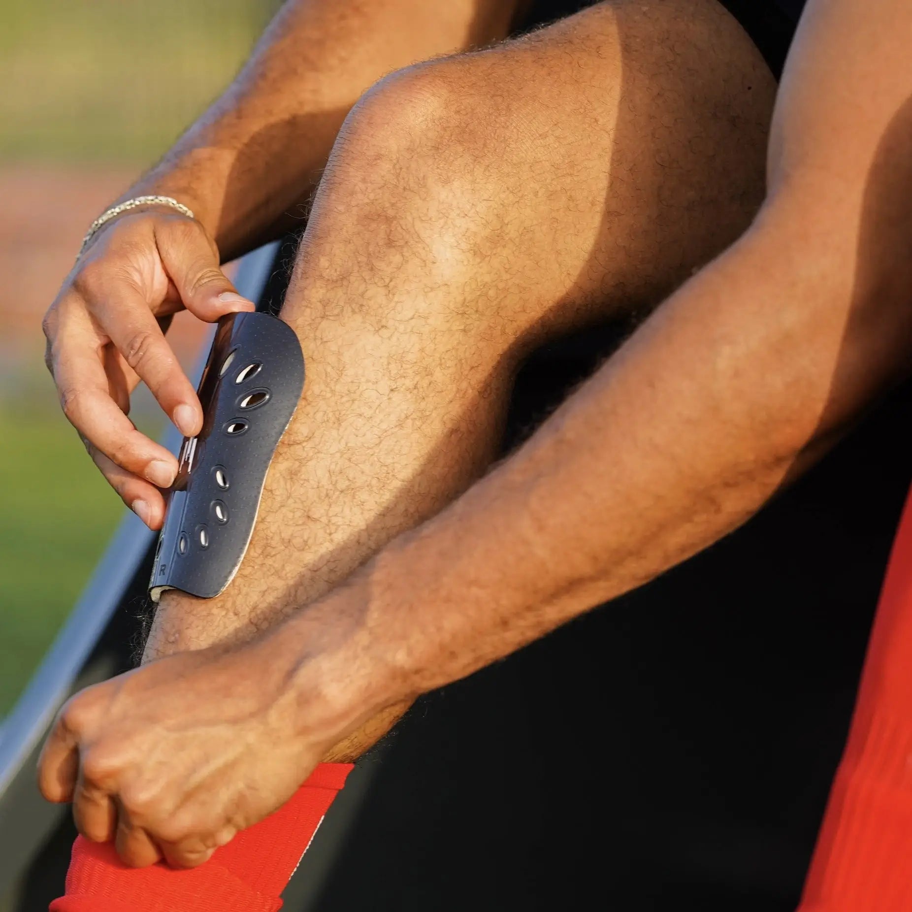 Joueur de foot plaçant sont petit protèges tibias dans sa chaussette de football