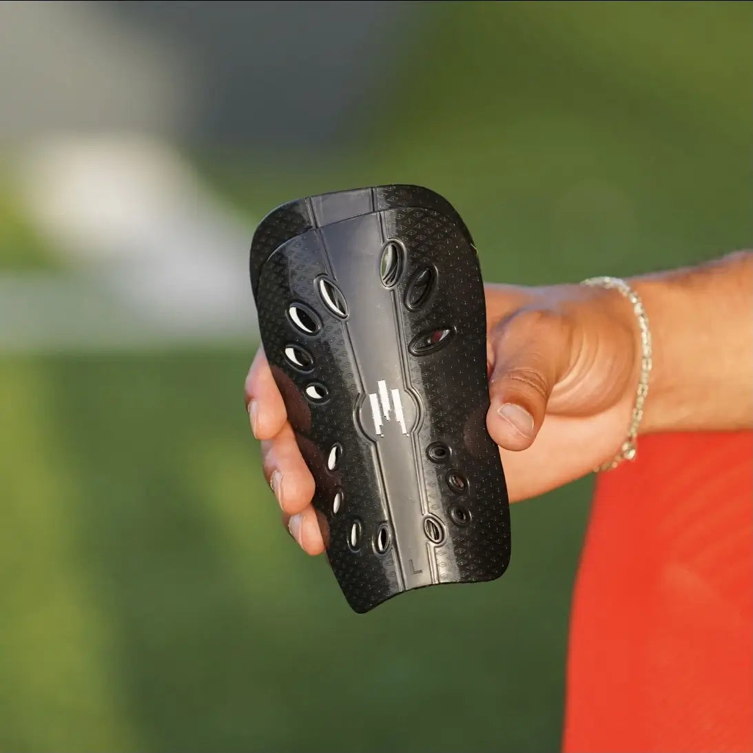 Photo des petits protèges tibias Tech Fly en main pour visualiser la taille de ces protèges