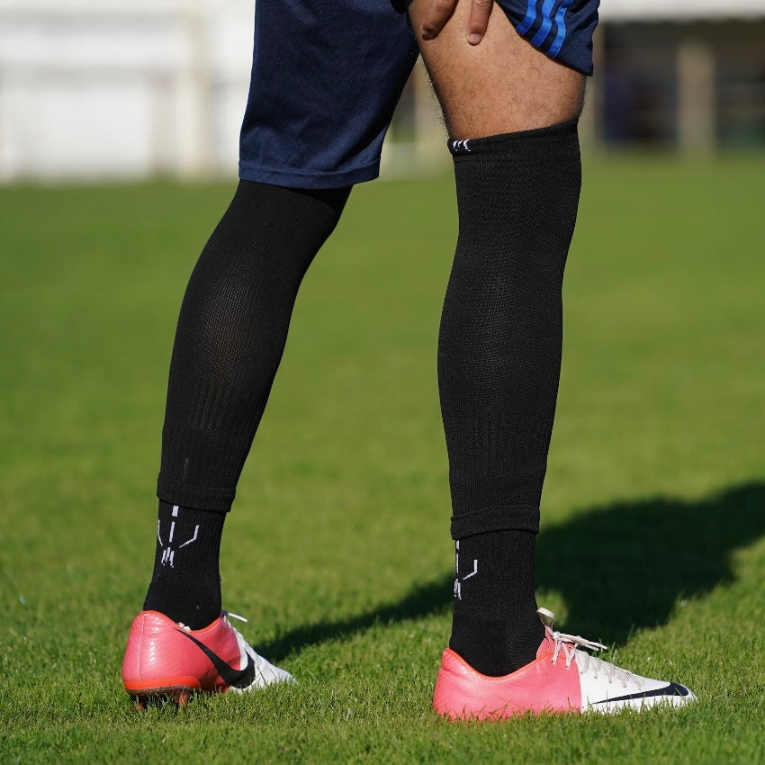 Combinaison des chaussettes de football coupées noires et chaussettes à grip antidérapant de football noires