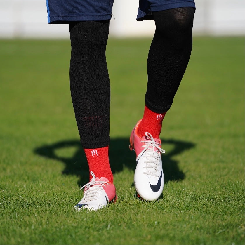 Combinaison des chaussettes de football coupées noires et chaussettes à grip antidérapant de football rouges