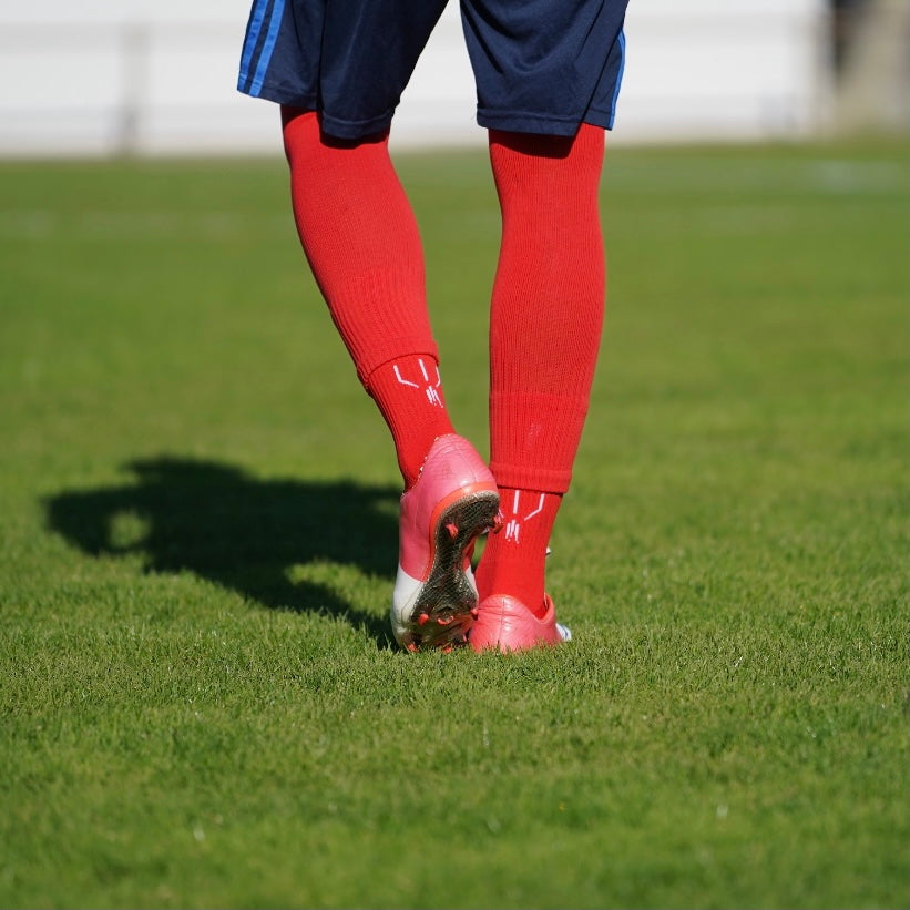 Combinaison des chaussettes de football coupées rouges et chaussettes à grip antidérapant de football rouges