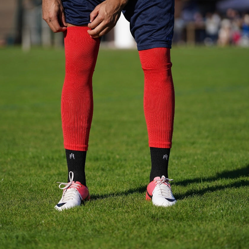 Combinaison des chaussettes de football coupées rouges et chaussettes à grip antidérapant de football noires